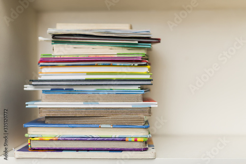 a shelf with a stack of colorful books on a bright day