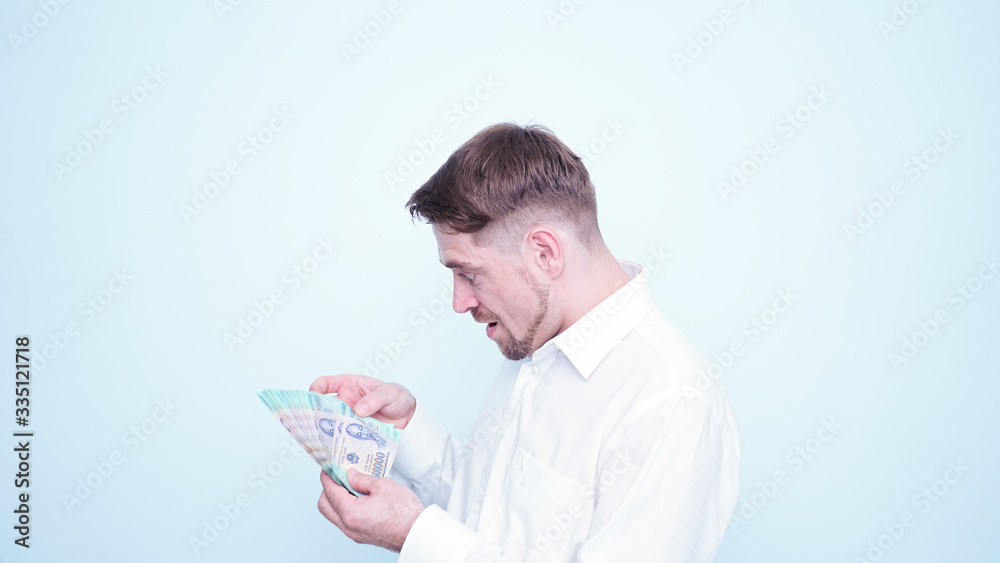 Emotional funny guy in white shirt counting vietnamese money.Portrait of young man taking Vietnam Dong money on his hand with happy emotions and smile on his face Emotional funny guy in white shirt counting vietnamese money.Portrait of young man taking Vietnam Dong money on his hand with happy emotions and smile on his face