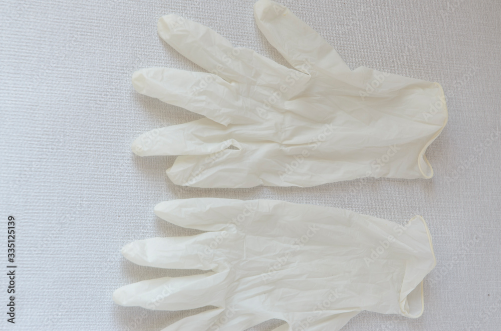 Obraz premium Medical glove, protection of hands from infections. White disposable glove on a gray background.