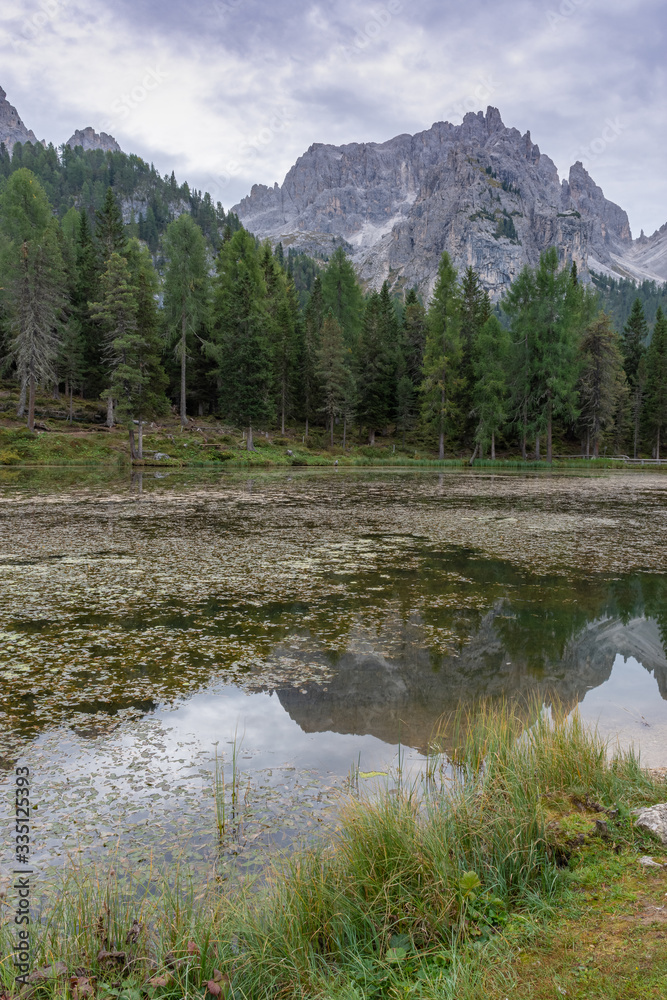 Italian Dolomites reflecting on the lake of Antorno on a cloudy autumn day