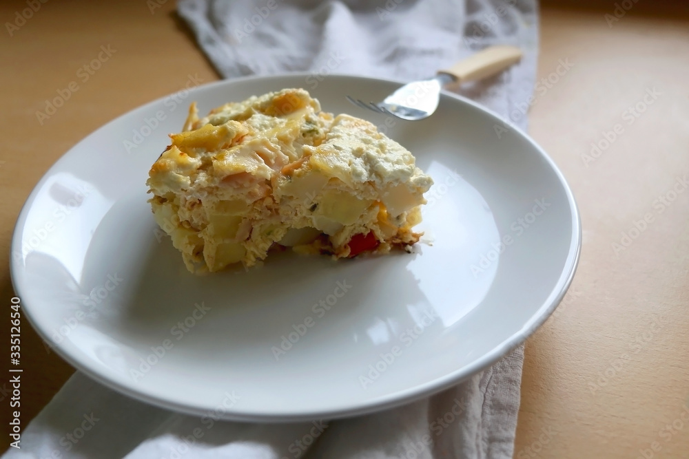 Potato, egg, ham and vegetable pie on a wooden table. Selective focus.