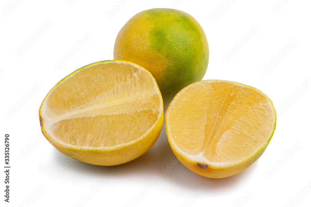 one whole yellow-green grapefruit and two halves on a white background. Isolate one whole yellow-green grapefruit and two halves on a white background. Isolate