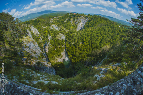 Overview of Skocjan caves way below the village of Skocjan on a picturesque summer day. Fish eye or wide angle view of Skocjan caves.