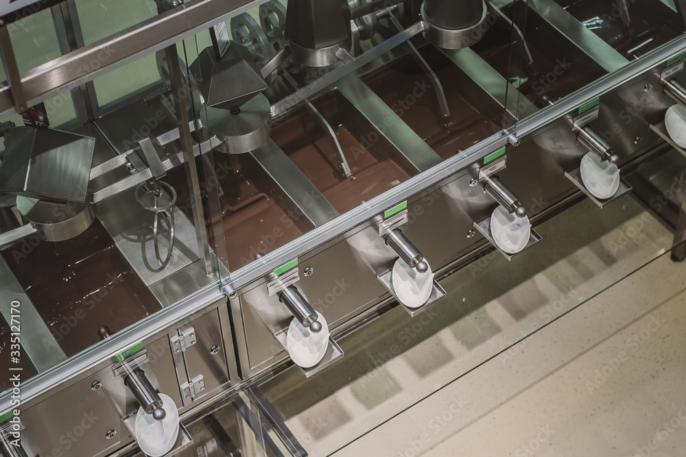 Industrial stirring of chocolate. Machines in chocolate factory stir the chocolate mixture in stainless steel containers. Industrial stirring of chocolate. Machines in chocolate factory stir the chocolate mixture in stainless steel containers.