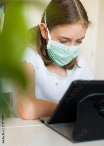 Little girl using tablet pc during quarantine.