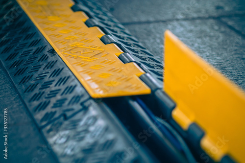 Obraz na plátně Black and yellow plastic cable protector on the ground
