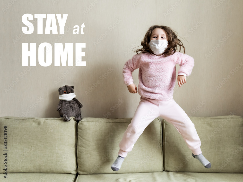 Stay at home in quarantine, funny kid jumping on couch during COVID19
