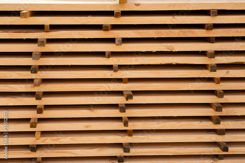 Warehouse for sawing boards on a sawmill outdoors. Timber mill  sawmill. Storage of planed wooden boards. Piles of wooden boards in the sawmill. Planking. Industry.