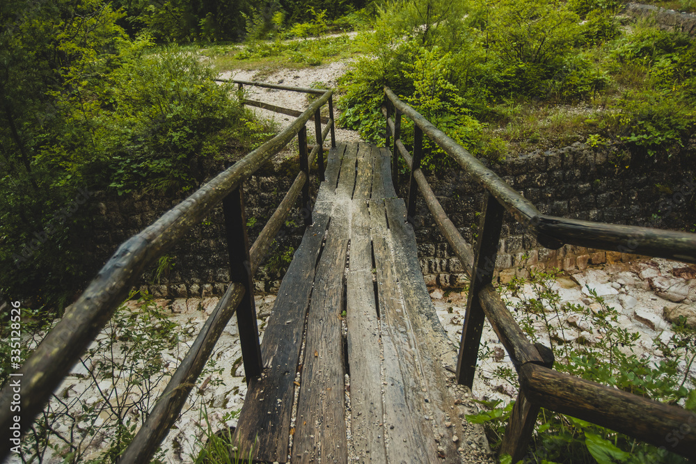 Slippery and dangerous wooden bridge for pedestrians in a countryside. Path leading through the woods over the wooden bridge Slippery and dangerous wooden bridge for pedestrians in a countryside. Path leading through the woods over the wooden bridge