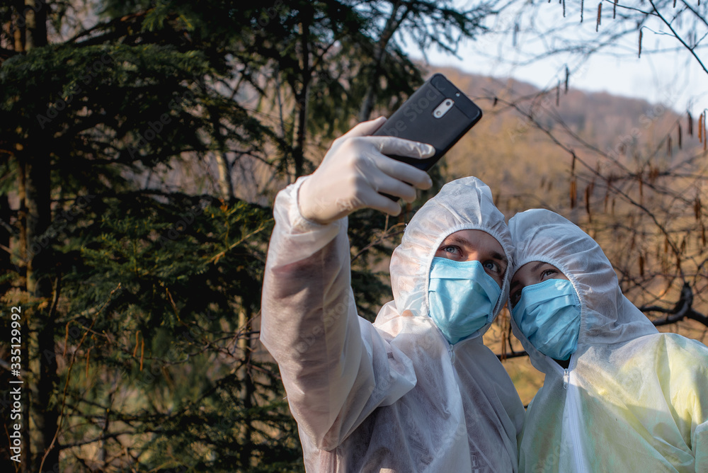 couple in protective clothes make selfie on nature couple in protective clothes make selfie on nature
