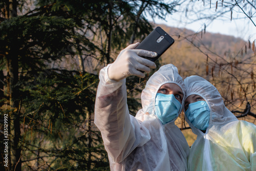 couple in protective clothes make selfie on nature