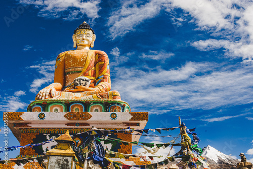 bgolden, buddha statue located with a blue cloudy sky in the background photo