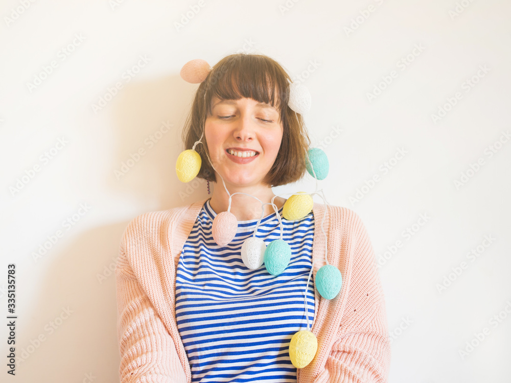 Easter concept female portrait with egg shaped decor festive lights. Spring pastel colors. Easter concept female portrait with egg shaped decor festive lights. Spring pastel colors.