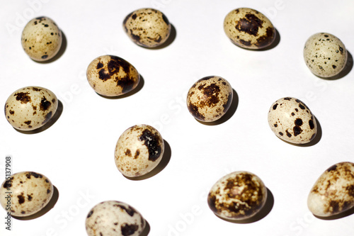 Quail eggs are scattered on a perfectly white background. The photo was taken close-up for any conceptual design and for Easter design, too.