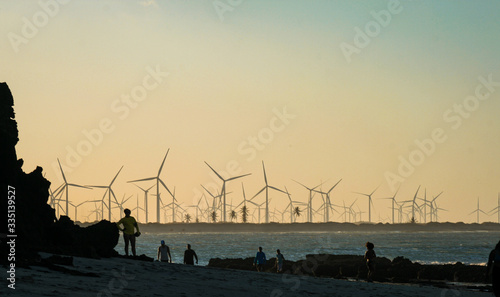 Turbines of wind power on the sunset on the beach