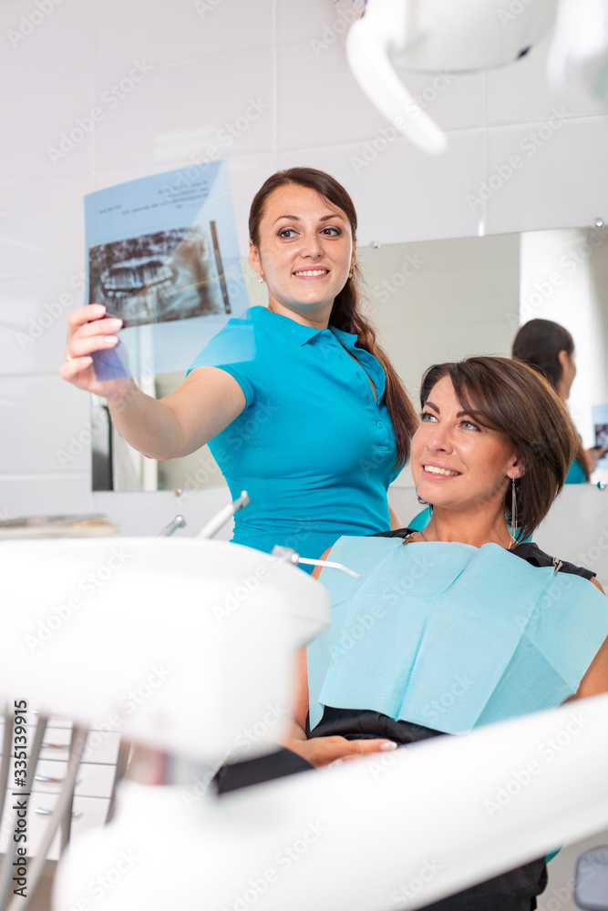 Dentist and patient are looking at x-ray picture. Check dental health. At the reception at the dentist. Dental treatment, modern medicine. Dentist and patient are looking at x-ray picture. Check dental health. At the reception at the dentist. Dental treatment, modern medicine.