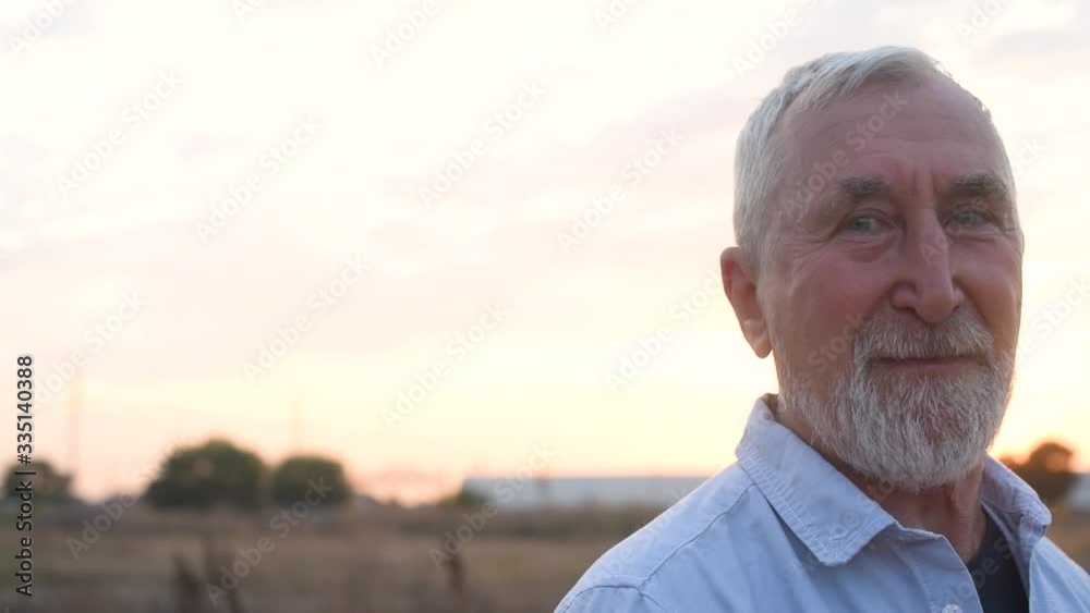 Elderly man with a gray beard at sunset in field, concept of emotions Elderly man with a gray beard at sunset in field, concept of emotions