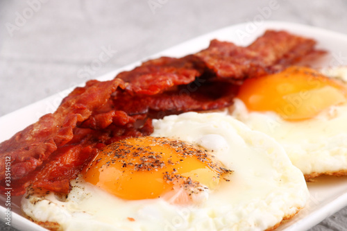 fried egg with bacon on plate. breakfast concept. close up