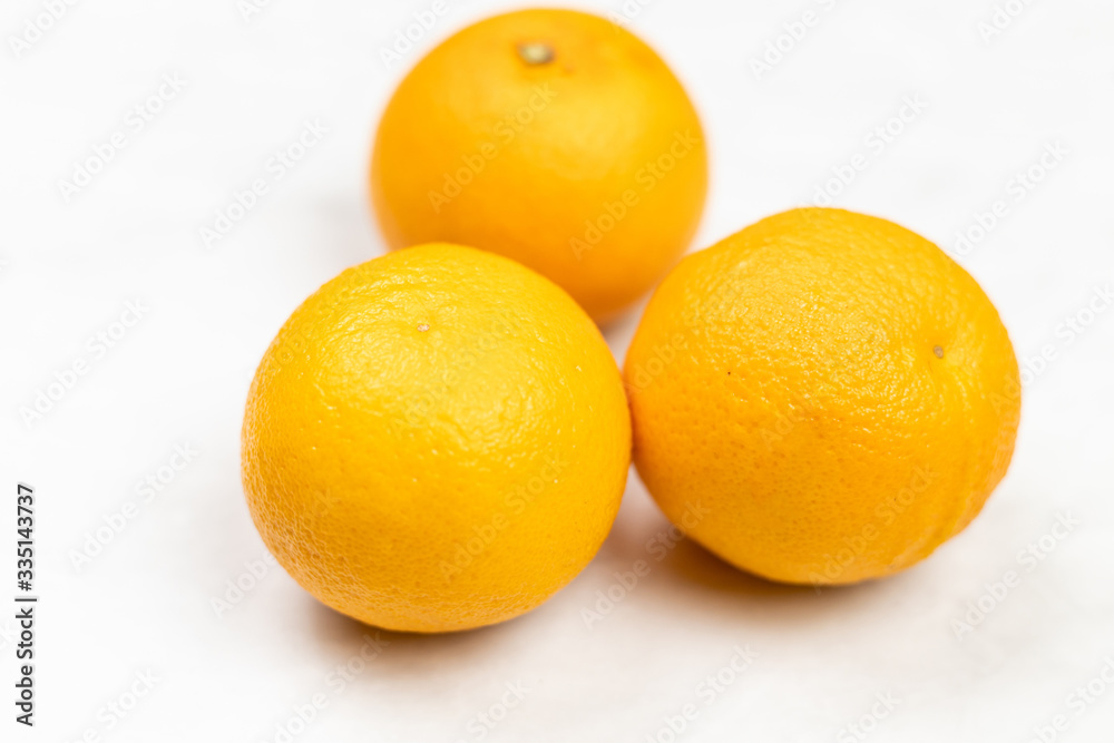 Raw oranges isolated above grey marble table with copy space. Raw oranges isolated above grey marble table with copy space.