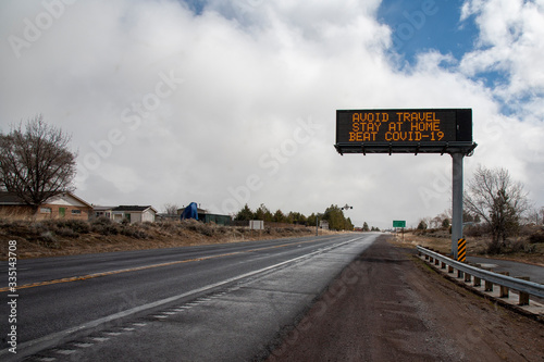 SUSANVILLE, CA - MARCH 25, 2020 - A California Department of Transportation (CALTRANS) information sign advises against travel during the COVID-19 crisis over a deserted US-395 highway. photo