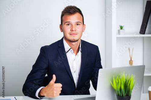 Solid businessman in a jacket works in office of company.