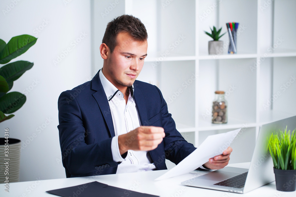 Solid businessman in a jacket works with documents in office of the company. Solid businessman in a jacket works with documents in office of the company.