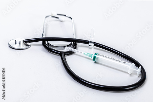 Phonendoscope and syringe on a white background.