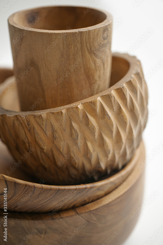 Fototapeta premium Wooden utensils for food on a white isolated background. Hand-made plates and a glass from an expensive variety of wood. Empty round deep tray, natural wood plate. Eco-friendly cookware.