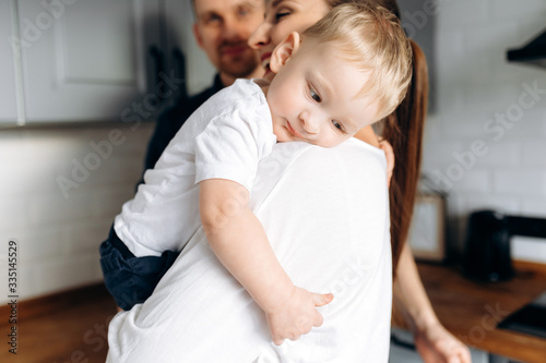 Adorable baby boy in the arms of his mother at cozy home