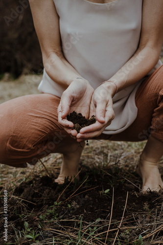 woman with hands in dirt from earth