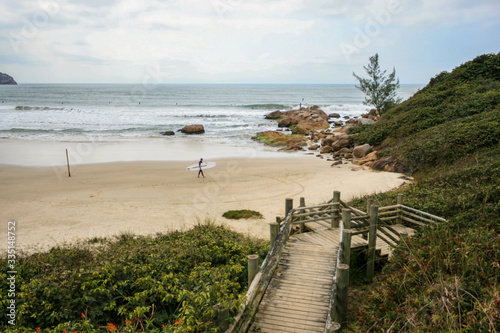 A surfer walking on the beach.