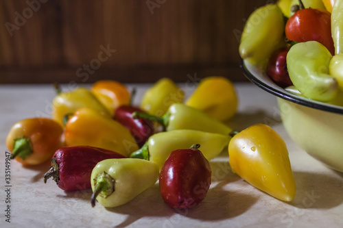Mix of a fresh red, yellow and orange peppers on a table. Fresh food concept, ripe vegetables.