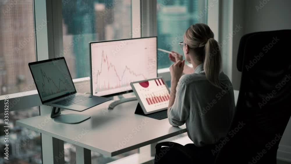 Experienced female broker working with trade stock exchange checking financial chart from market block chain connected to corporate wifi in office interior, skilled woman with electronic stylus 
