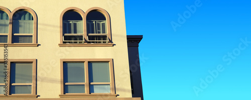 concrete building with ark windows yellow wall and blue sky photo