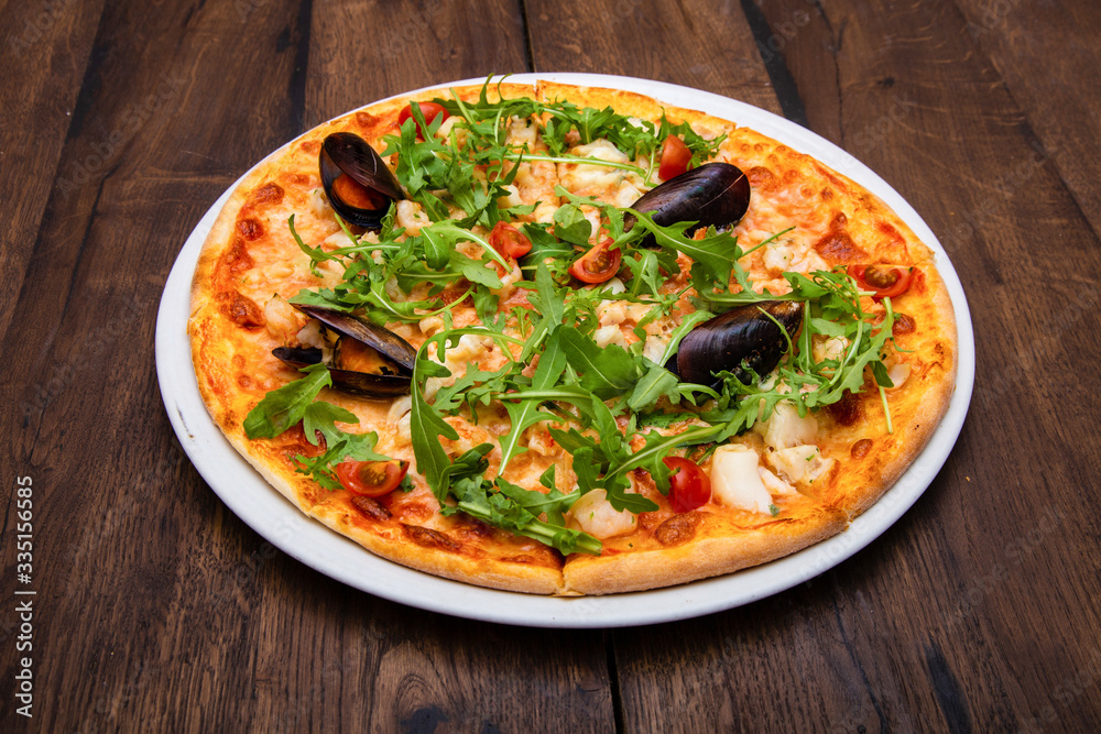 classic Italian pizza with mussels on a wooden table classic Italian pizza with mussels on a wooden table
