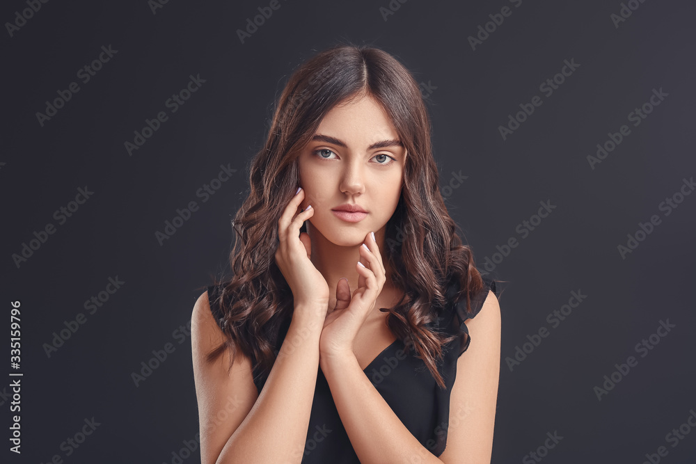 Fototapeta premium Young woman with beautiful curly hair on dark background