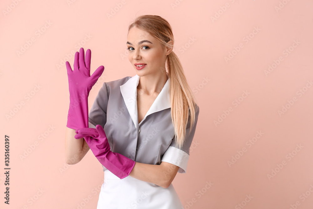 Beautiful young chambermaid on color background Beautiful young chambermaid on color background