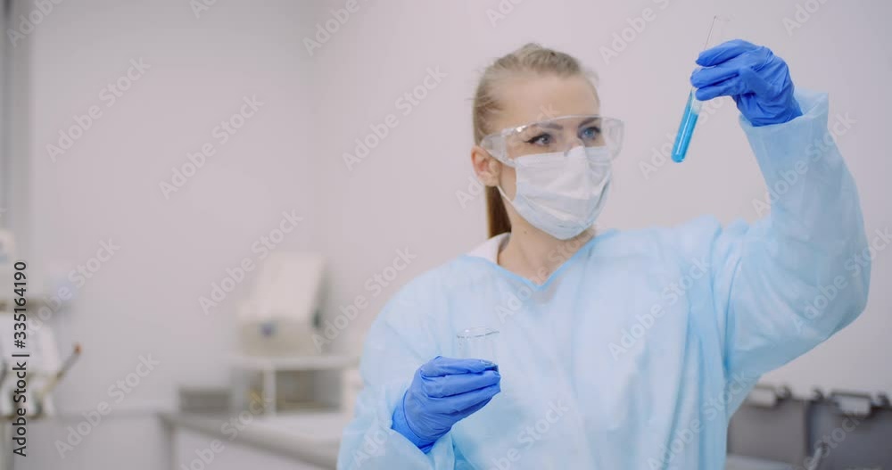 Female Scientist Holding Tubes and Flask with Liquid in Hands. Female Scientist Holding Tubes and Flask with Liquid in Hands.