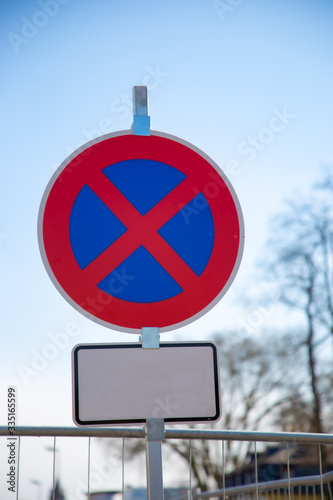 Traffic sign in red and blue with additional sign in white, indicating the area and date where and when parking and stopping is forbidden