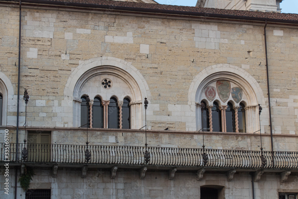 Windows at the inner yard of medieval palace Palazzo del Broletto, Brescia, Lombardy, Italy.