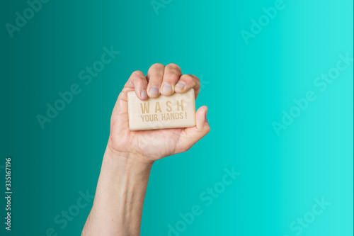 Caucasian male hand holding bar of soap with message 