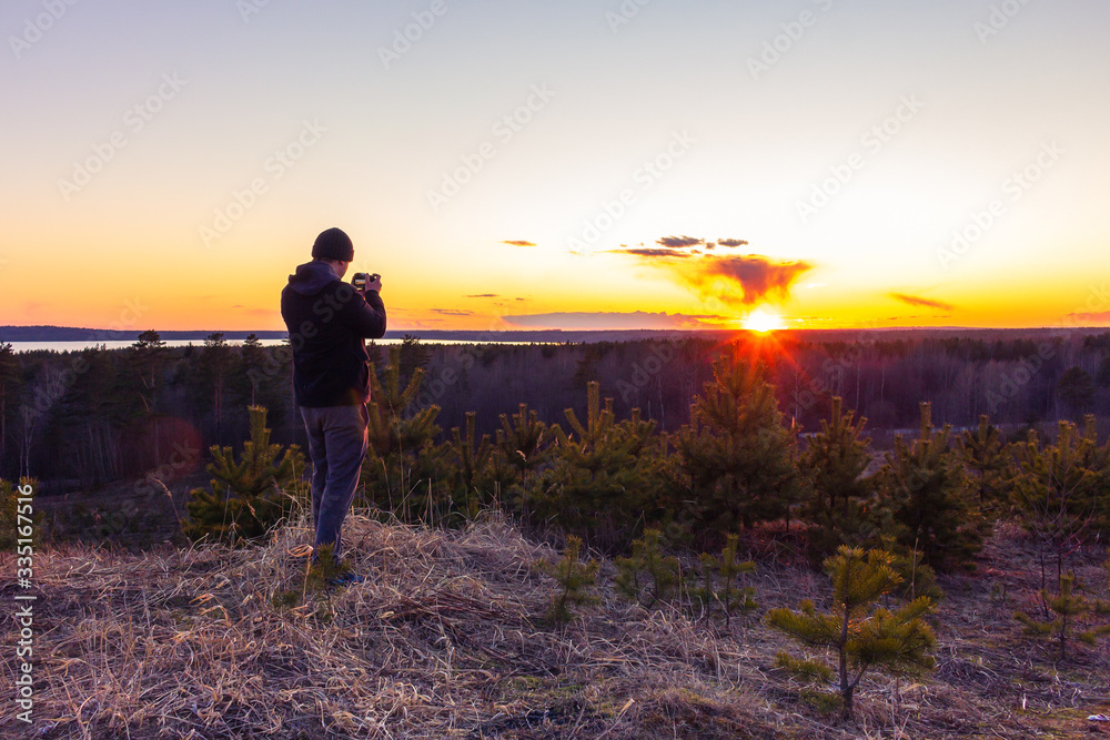 photographer shoots a sunset on top of a mountain