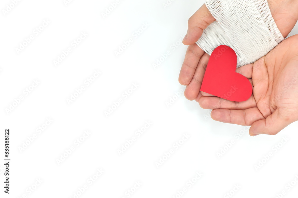 Cupped hands with bandage holding a red heart. Sacrifice, organ donation, charity and genuine love and kindness. Cupped hands with bandage holding a red heart. Sacrifice, organ donation, charity and genuine love and kindness.