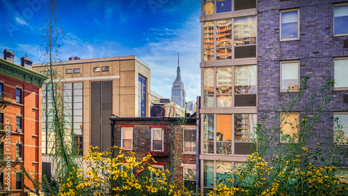 Fototapeta Naklejka Na Ścianę i Meble -  New York City, the popular Empire State Building from a special view framed by house facades from the viewpoint of the highline.