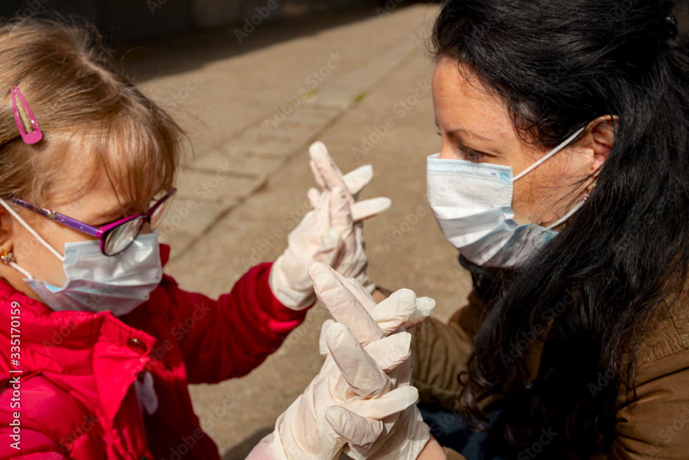 Mother with her daughter have medical gloves and masks, they are worry