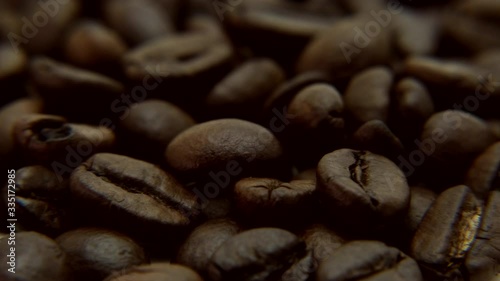 Roasted coffee beans background. Close-up of roasted coffee beans spinning slowly in a circle. Roasted coffee bean background, top view. footage 360 rotation