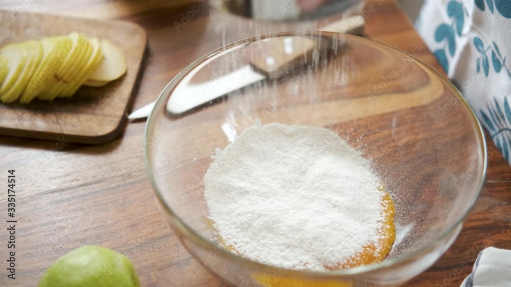 close-up sifts the flour into a transparent bowl