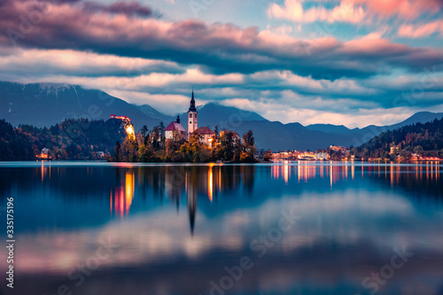 Dramatic morning view of Pilgrimage Church of the Assumption of Maria. Calm autumn sunrise on Bled lake, Julian Alps, Slovenia, Europe. Traveling concept background.