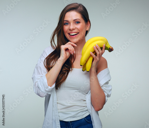 woman holding bananas. girl dressed white casual clothes