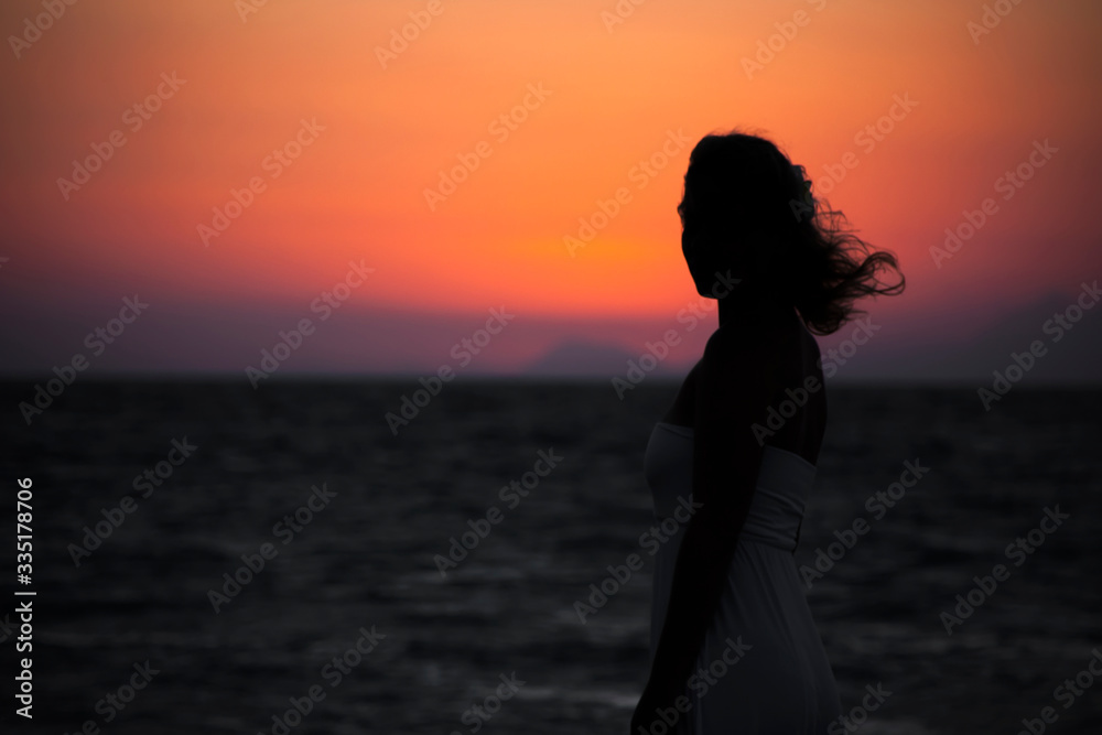 Silhouette of a girl on a sunset background in the sky